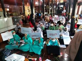 foto peserta sedang melihatkan hasil gambar batik yang mereka buat